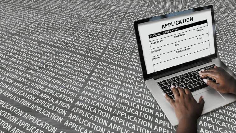 Hände am Laptop schreiben eine Bewerbung