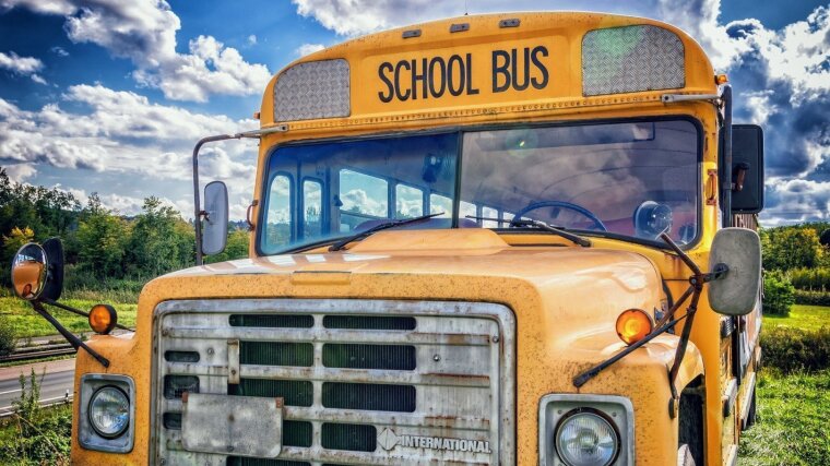 Amerikanischer Schulbus am Straßenrand unter blauem Himmel und weißen Wolken