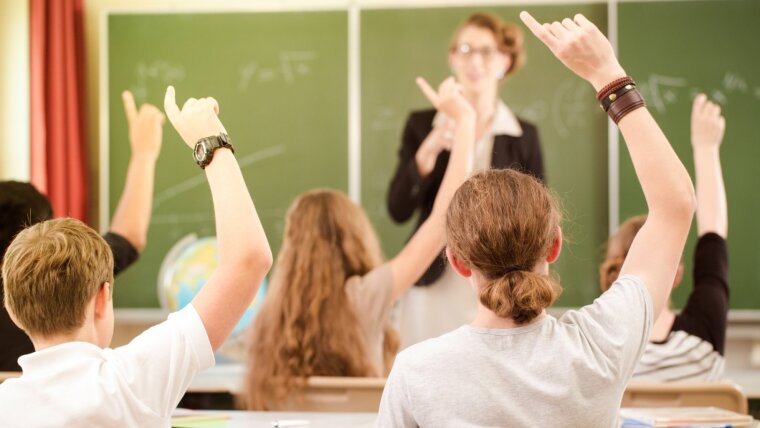 Schülerinnen und Schüler im Klassenraum mit Lehrerin