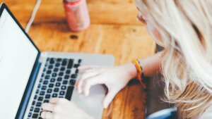 Frau sitzt am Laptop und arbeitet