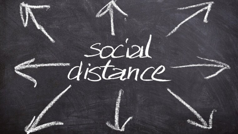 Social distance geschrieben auf einer Tafel.