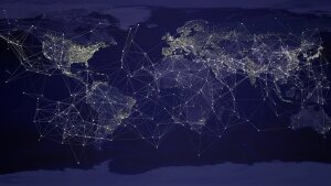 Weltkarte in dunklen Farben mit Vernetzungen zwischen einzelnen Städten durch helle Linien